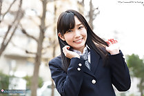 Student outdoors in uniform hands raised playing with her long hair