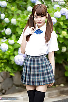Student in uniform playing with her pigtails wearing pleated skirt