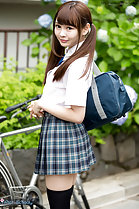 Atomi Shuri standing beside bicycle hair in pigtails holding school bag