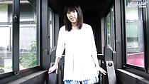 Machiko standing in corridor white top in denim short skirt