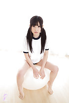 Student seated on ball hair in pigtails bare feet
