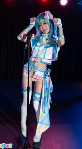 Ria Kurumi standing at microphone lowering her panties