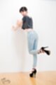 Leaning against wall wearing jeans high heels