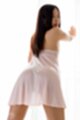 Leaning against curtained window looking over her shoulder sheer lingerie long hair down her back