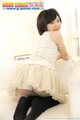 Mei kadowaki kneeling on couch looking over her shoulder wearing short skirt