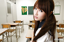 Seated at her desk looking over her shoulder long hair in pigtails