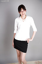Office lady wearing white shirt in black short skirt standing with hand on hip