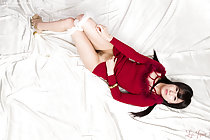 Lying on her back pulling panties down raising hem of dress exposing her pussy