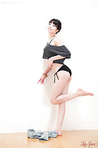 Standing against wall wearing panties bare feet