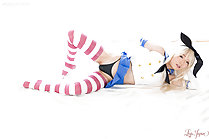 Lying on her side skirt raised showing black panties in striped stockings