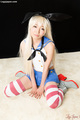 Bunny girl kneeling in skirt wearing striped stockings