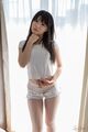 Sakura sena standing in front of curtained window pulling tee shirt down over her tits in shorts