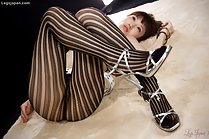 On her back knees drawn up wearing pantyhose high heels