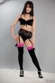 Standing with hands on hips wearing lingerie in stockings wearing high heels