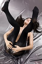 Sakura Sena lying on her back legs raised in black pantyhose