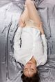 Lying on her back wearing shirt hands on hips