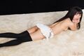 Lying on her front looking back short skirt in black stockings high heels