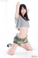 Tojo aki kneeling arms raised wearing crop top in short skirt