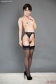 Nude wearing stockings in garter belt wearing black high heels