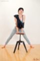 Leaning on stool blue jeans bare feet