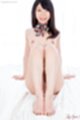 Seated nude knees drawn up bare feet