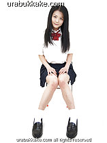 Kogal seated on chair in uniform long hair down to her chest hands on her thighs knees pressed together