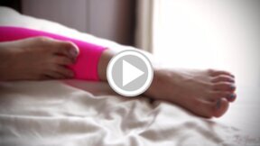 Mizuki in pink leggings and ankle bracelet playing with her bare feet